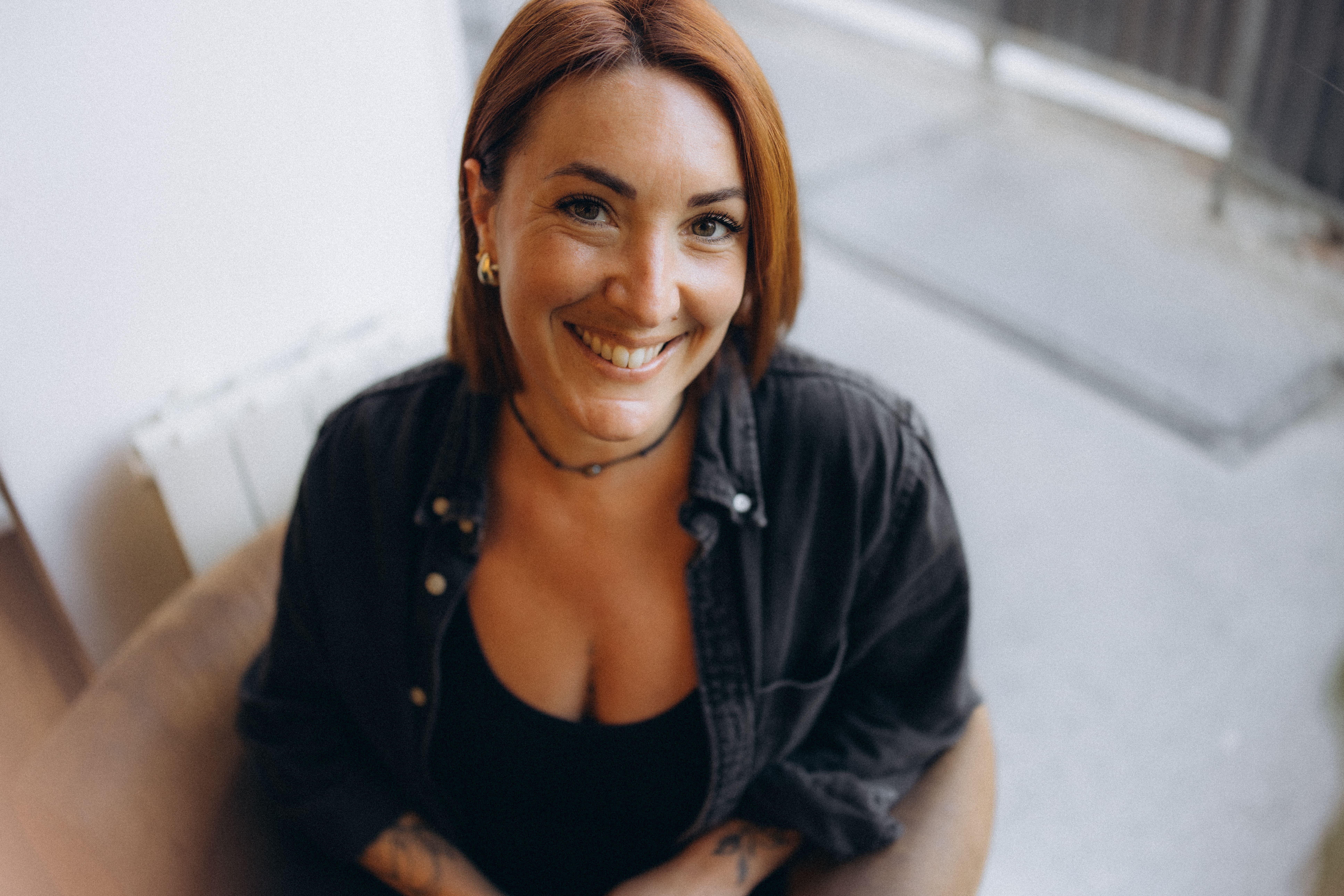 Portrait de Georgie, Digital Strategist, souriante et vêtue d'un pull vert, posant dans un fauteuil avec une décoration moderne en arrière-plan. Le texte sur l'image pose la question 'Fatigué(e) de lutter avec ta communication digitale ?' mettant en avant le thème de l'accompagnement pour les chefs d'entreprise dans le secteur de la beauté.